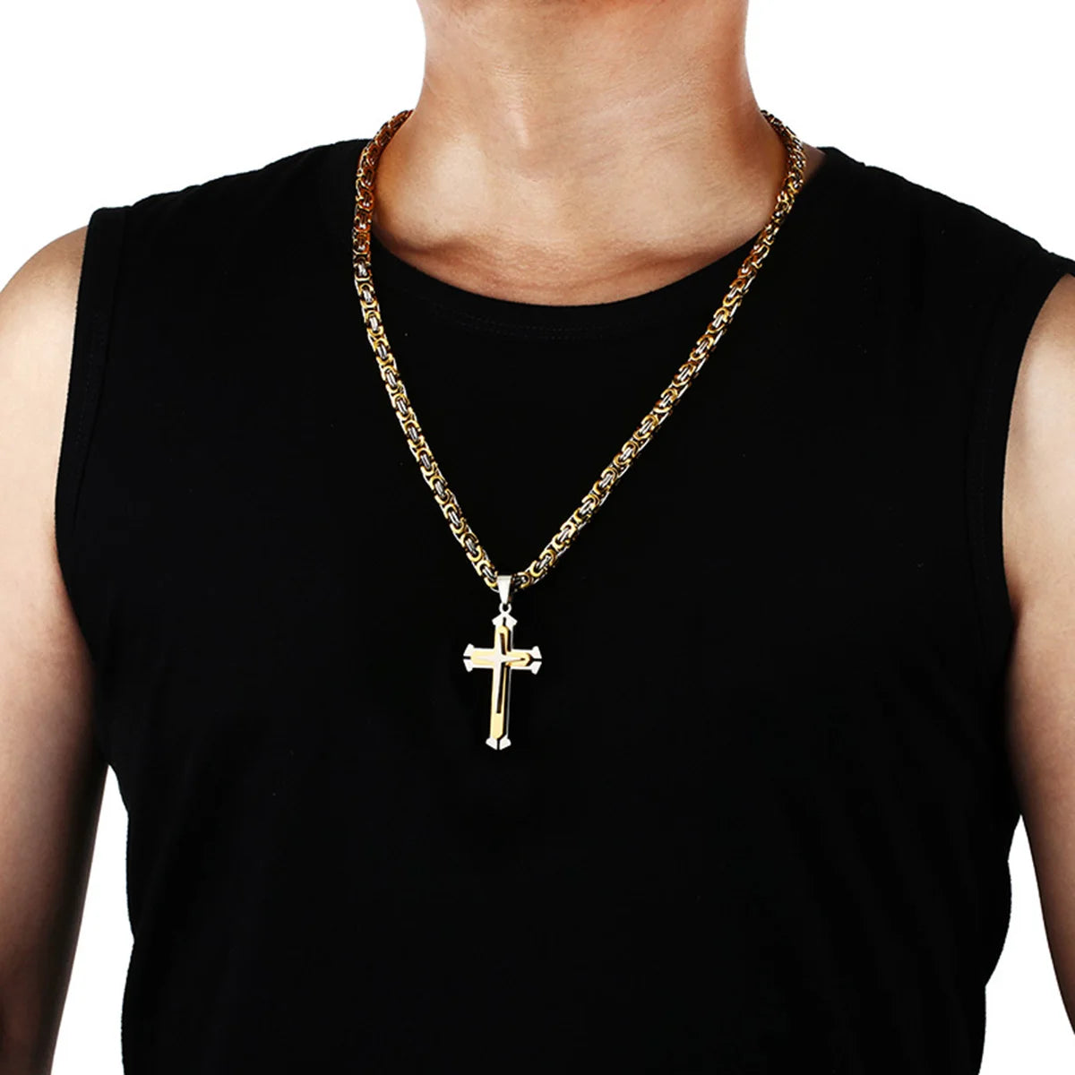 silver and gold cross and chain hanging on mans neck