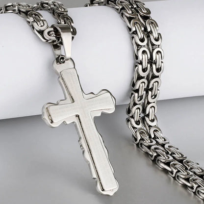 all silver cross and chain displayed with jewelry holder