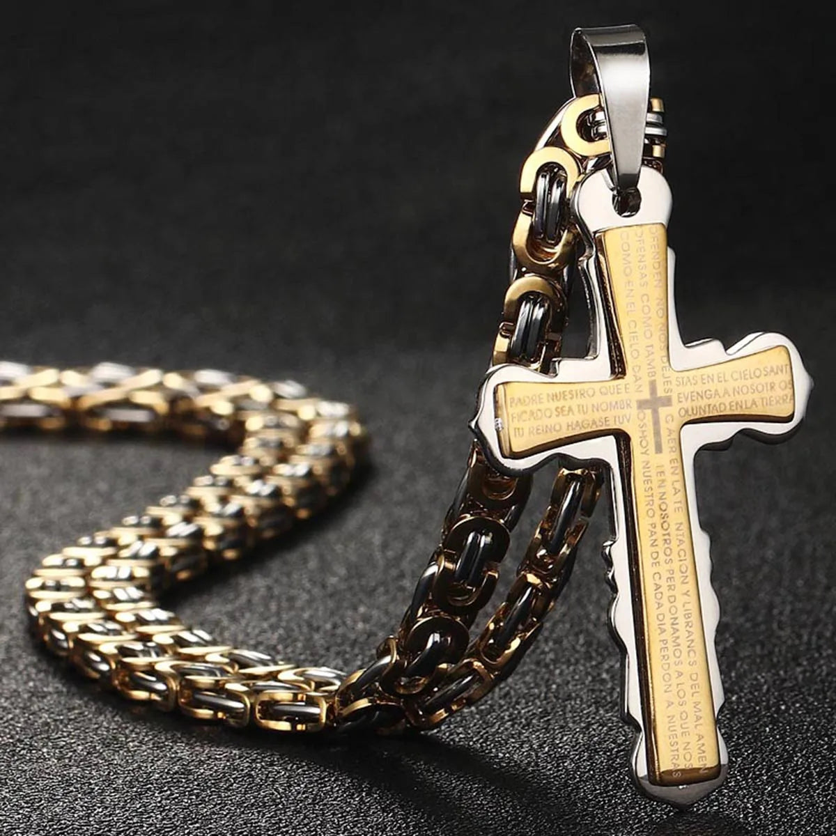 Gold and silver cross standing up on table with chain in back