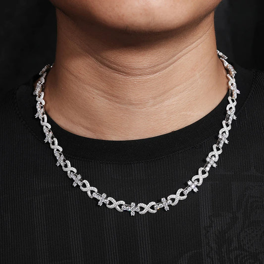 Moissanite crosses cuban chain around a persons neck silver